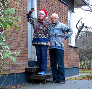Evve och Gunnar poserar med tomtemössor vid sitt nya hem.